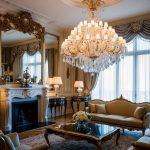 A grand chandelier illuminates a regal living room with ornate furniture and intricate details, exuding timeless elegance and classic style